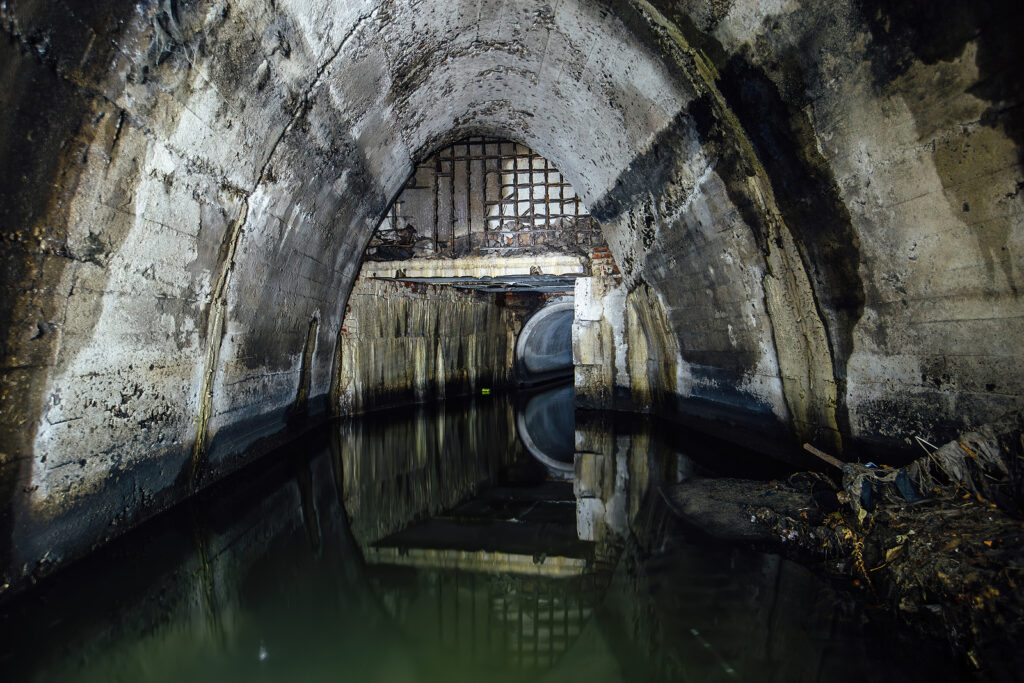 Flooded Underground Urban Sewer Tunnel. Large Sewage Collector.